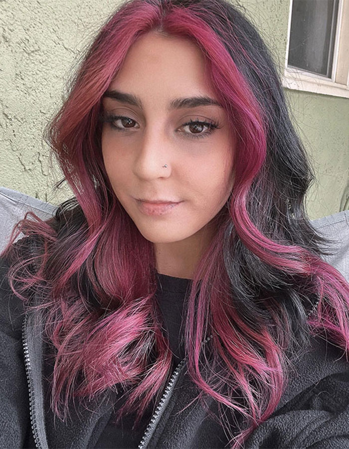 Young woman with pink and black hair, wearing a black jacket, related to 7-Eleven manager coworker incident story.