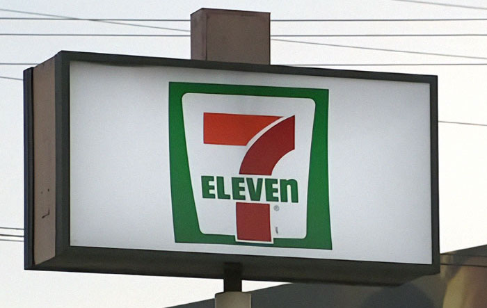 7-Eleven store sign glowing at dusk, representing the location linked to horrific coworker incident.