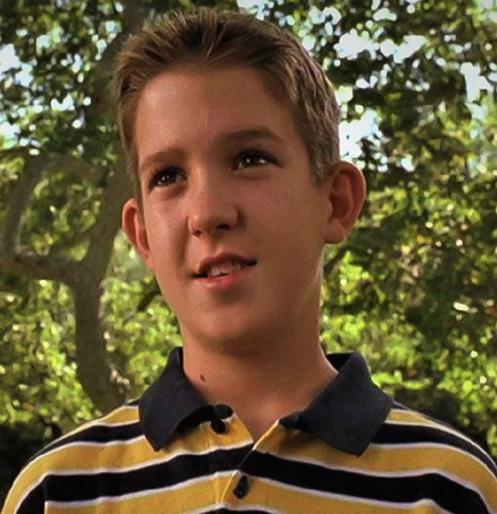 Young boy wearing a striped polo shirt outdoors, representing unsolved disappearances of celebrities and important figures.