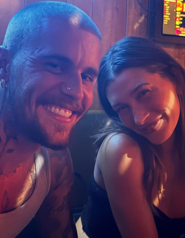 Justin Bieber and Kendall Jenner smiling together in a dimly lit dive bar, sparking social media buzz.