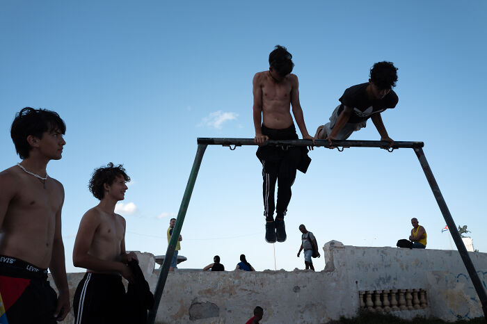 Teen boys enjoying outdoor activity on playground captured by street photographer showcasing beauty of ordinary life.