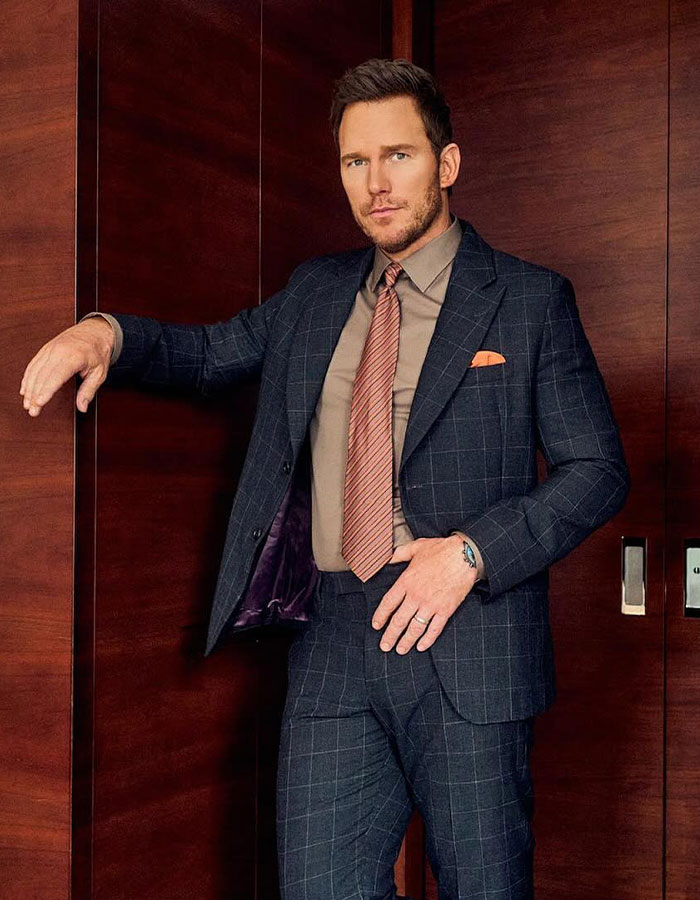 Man in a checked suit posing indoors, related to Katy Perry renting Chris Pratt a $15 million property. - 3