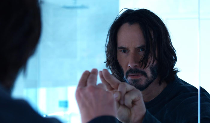 Keanu Reeves looking intently at his reflection while touching a glass, AI transformed with Jack Sparrow elements.