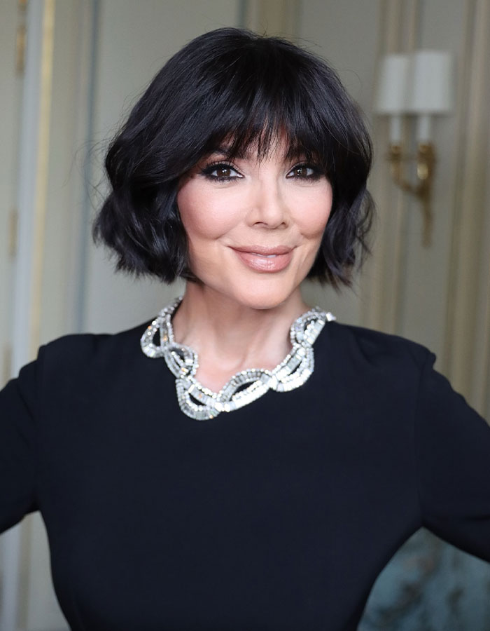 Kris Jenner with short black hair and a jeweled necklace posing indoors, addressing viral facelift and aging gracefully. Kris Jenner with short black hair and a jeweled necklace posing indoors, addressing viral facelift and aging gracefully.