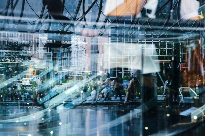 City street scene reflected in glass, showcasing poetic and cinematic photography capturing ordinary moments in an urban setting.