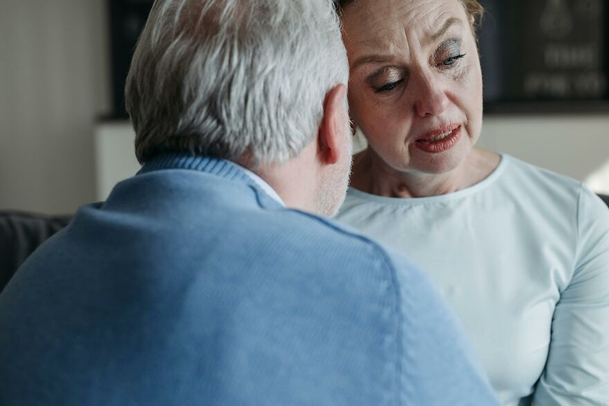 Older couple having a serious conversation indoors, illustrating relationship issues related to men cheating and the closing gender gap.