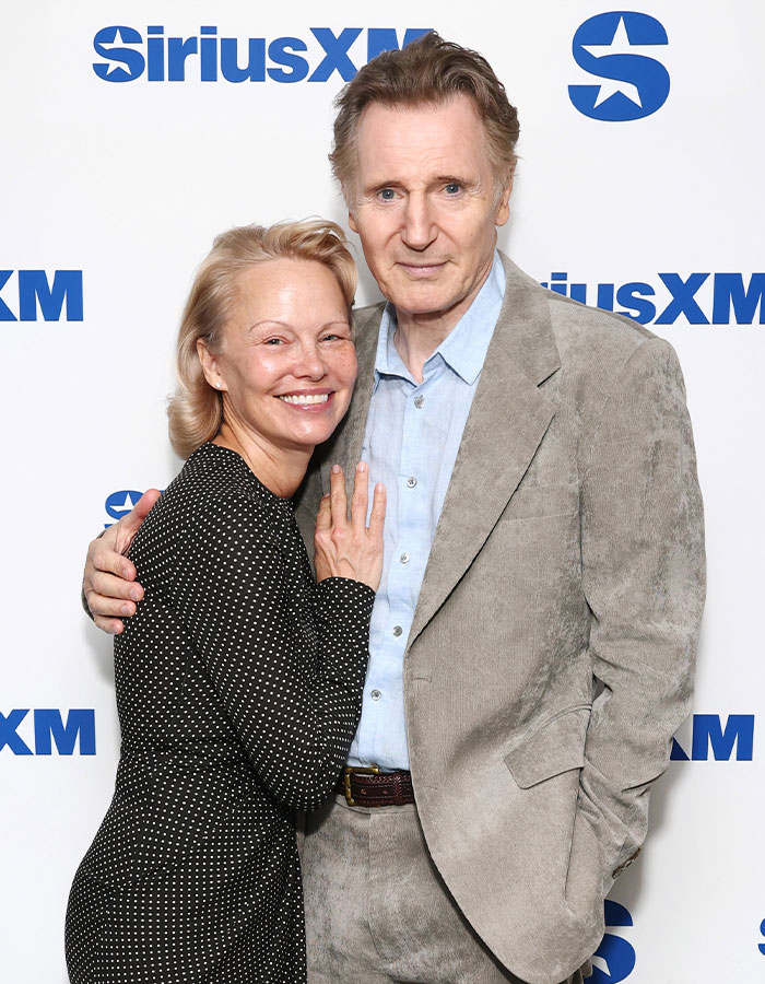 Liam Neeson with a woman at SiriusXM event, smiling and posing for the camera, discussing rumored romance news - 7