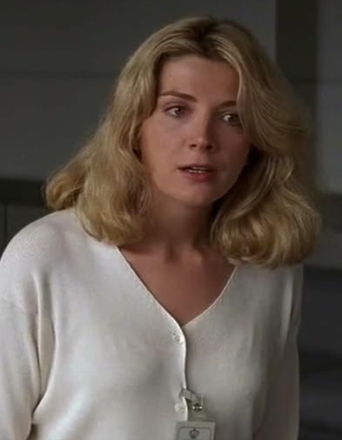 Woman with blonde hair wearing a white top reacting emotionally, related to Liam Neeson's rumored romance with Pamela Anderson. - 5