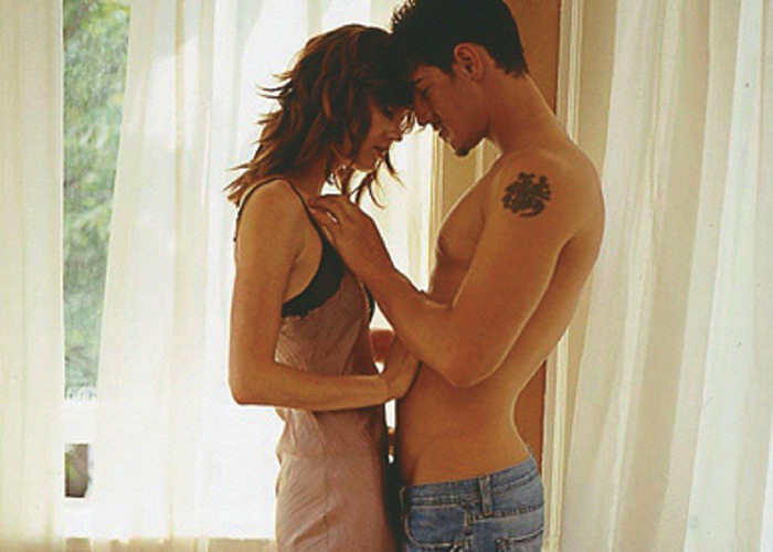 Couple in intimate moment on film set, highlighting movie stars filming love-making scenes with genuine passion.