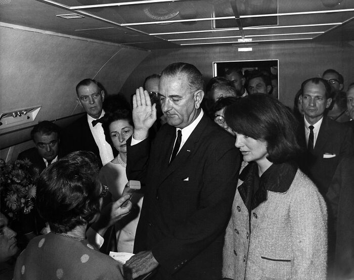 Lyndon B. Johnson taking the oath of office aboard Air Force One, a key moment in 20th century history images.