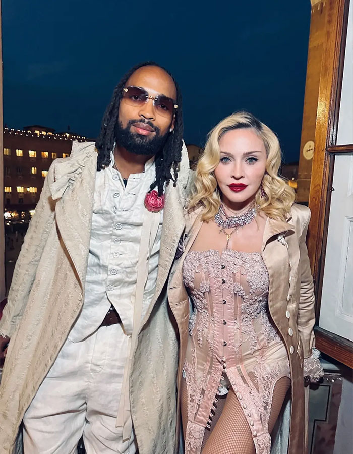 Madonna with her 29-year-old boyfriend at night, both dressed in stylish vintage-inspired outfits outdoors.