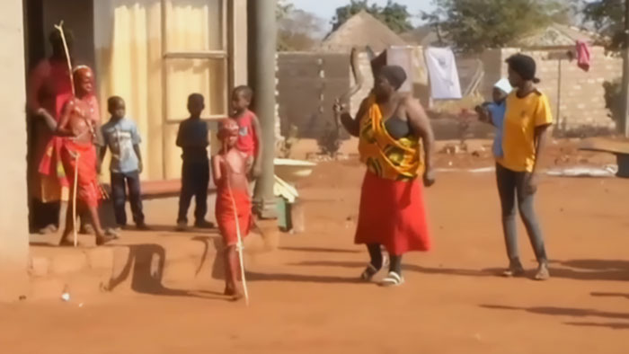Community members gather outdoors during a mass circumcision ceremony amid reports of tragic mutilations. - 1