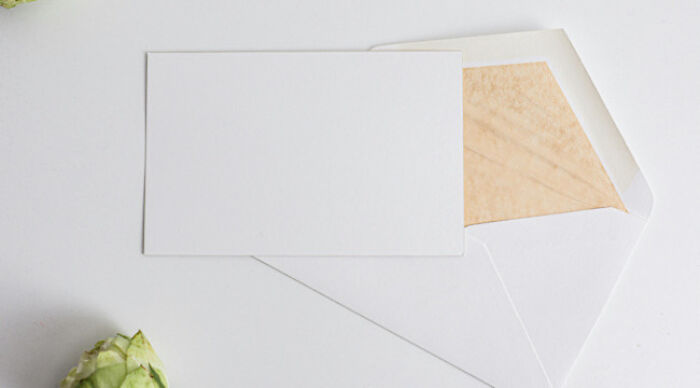 Blank white card lying on an open envelope with a moral dilemma poll theme and soft natural lighting background.