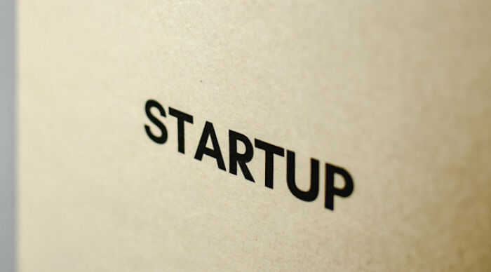 Close-up of the word startup printed in bold black letters on a textured beige background, focusing on moral dilemma concepts.