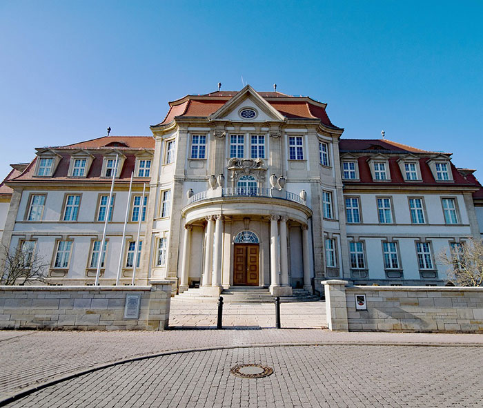 Large historic courthouse building under clear sky, related to radical right-winger serving sentence in women's jail.