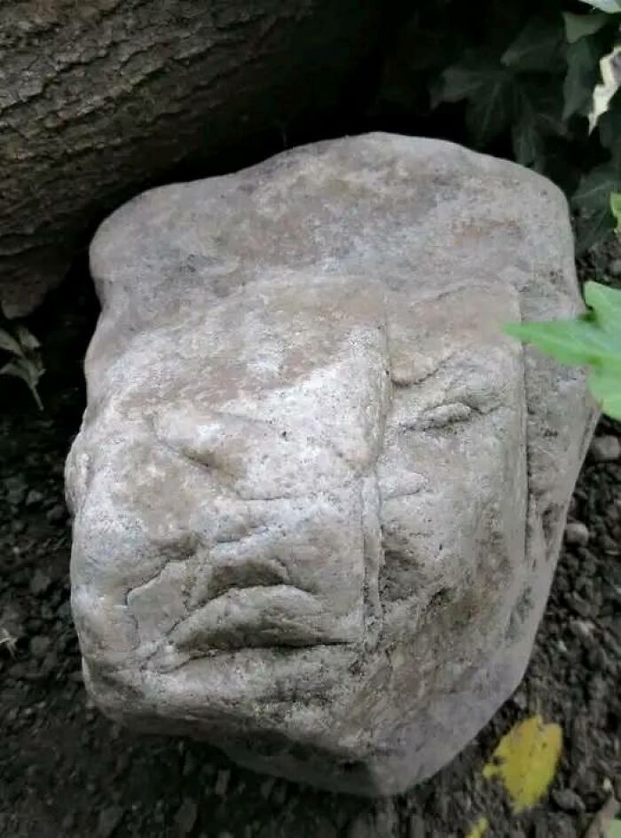 Rock with natural patterns and cracks resembling a face posted in a Facebook group about objects that look like faces.