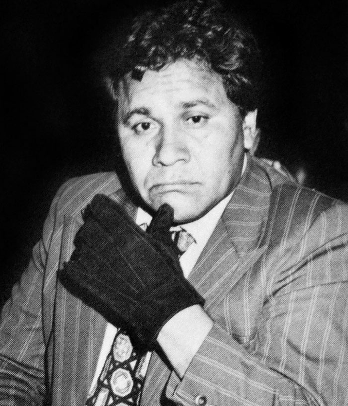 Black and white photo of a man in a striped suit and gloves, related to celebrities and important figures disappearances unsolved.
