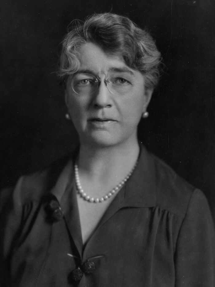 Black and white portrait of a woman scientist wearing glasses and pearls, representing remarkable women scientists.