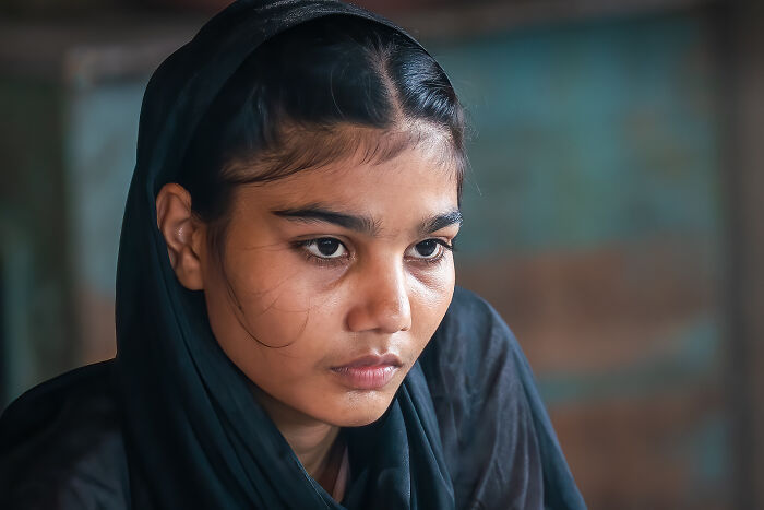 Close-up portrait of a young woman in traditional clothing, showcasing cultural beauty captured by traveler photographer.
