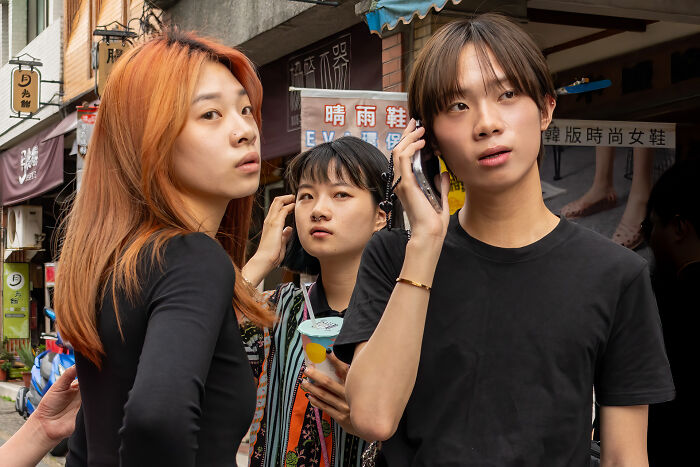 Three young people in an urban street scene, capturing the beauty of cultures through diverse expressions.