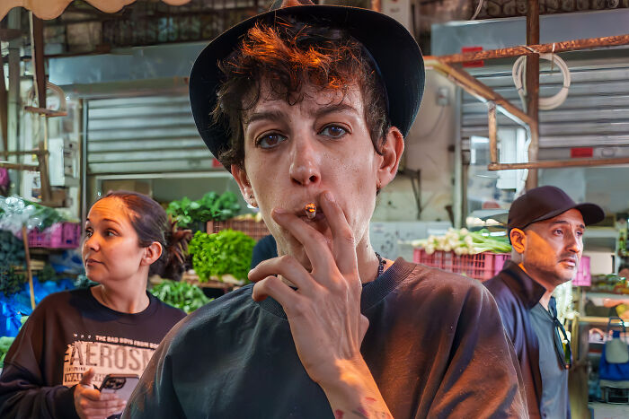 Photographer capturing vibrant cultural scenes in a bustling market, showcasing diverse people and local atmosphere.