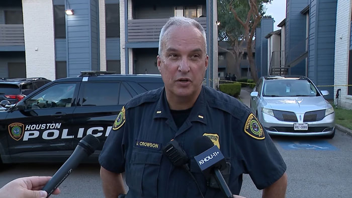 Houston police officer speaking to reporters outside apartment complex after toddlers asked for food, leading to a distressing discovery.