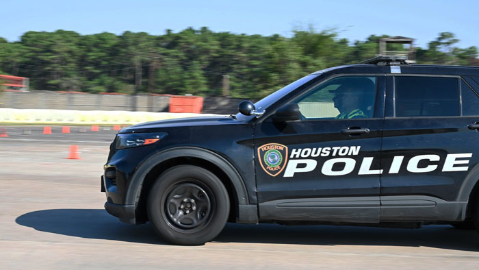 Houston police vehicle driving past cones, responding to a scene involving hungry and thirsty toddlers inside a house.