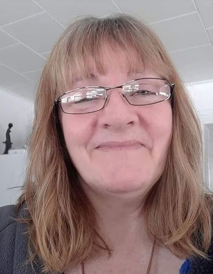 Woman with glasses smiling indoors, related to polygraph results made public for parents of missing kids.