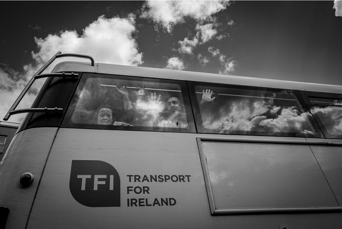 Black and white photograph of two people inside a bus, capturing the hidden poetry of everyday life.