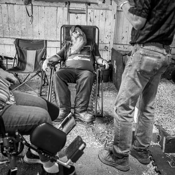 Black and white photograph of a bearded man relaxing in a chair, capturing the hidden poetry of everyday life.