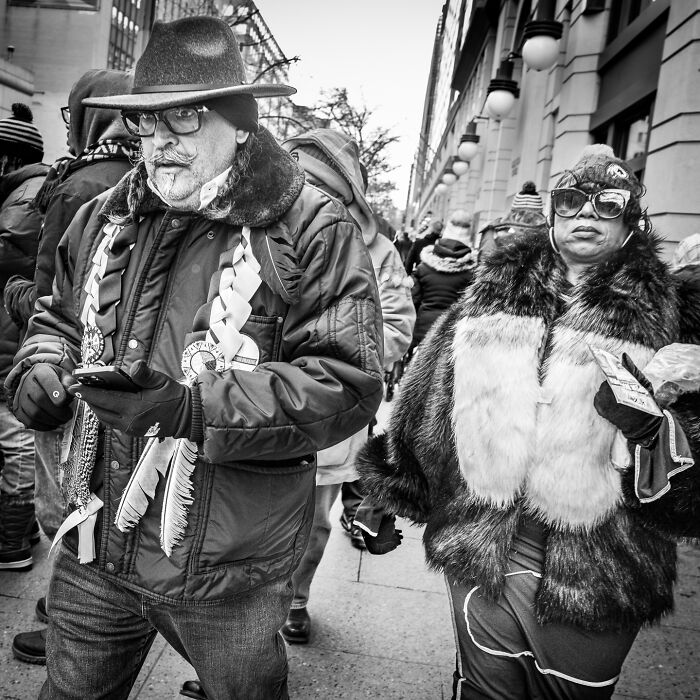 Black and white street photograph capturing the hidden poetry of everyday life with stylish pedestrians in winter attire.
