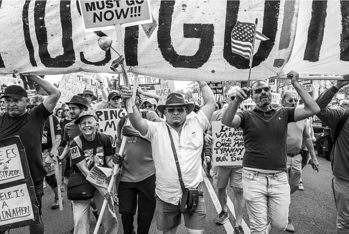 Black and white photo capturing the hidden poetry of everyday life through a dynamic protest scene.
