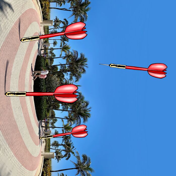 Outdoor landscape reimagined with giant cartoon darts and palm trees under a clear blue sky.