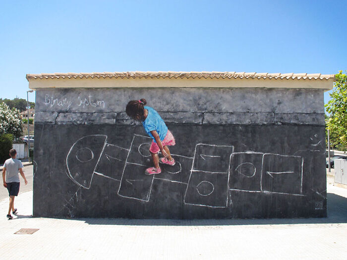 Child playing hopscotch on street art mural painted on a wall depicting a binary system concept outdoors.