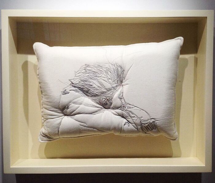 Embroidered pillow featuring a detailed sleeping figure design, capturing the beauty of sleep in soft fabric art.