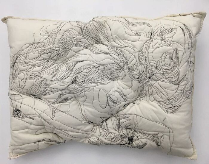 Embroidered pillow with intricate black thread art depicting a sleeping figure, showcasing dreamy embroidered pillows design.