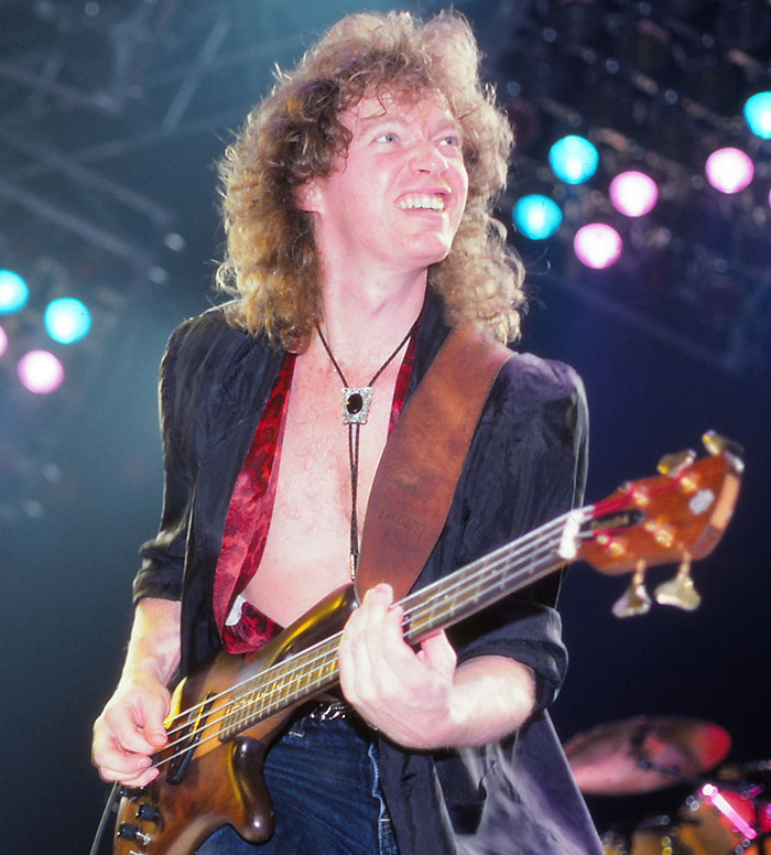 Musician playing bass guitar on stage with colorful lights, representing celebrities whose disappearances remain unsolved.