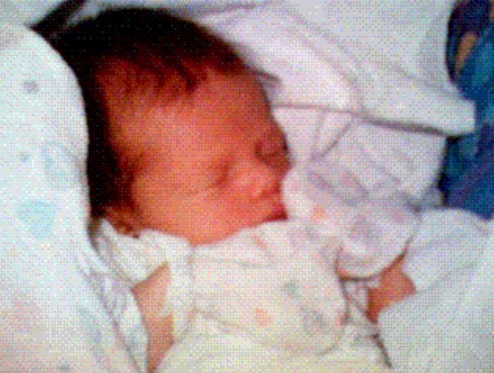 Newborn baby sleeping peacefully wrapped in a blanket, symbolizing the triumph and tragedy of the 20th century.