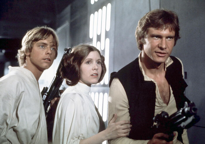 Luke Skywalker, Princess Leia, and Han Solo in a dramatic scene, representing heartwarming and harmless secrets shared.