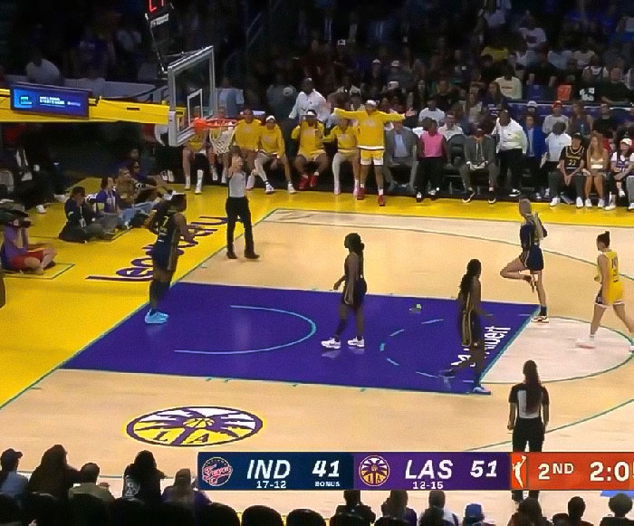 WNBA game action on court with players and bench reacting to viral footage of flying dildo incident during match. - 3