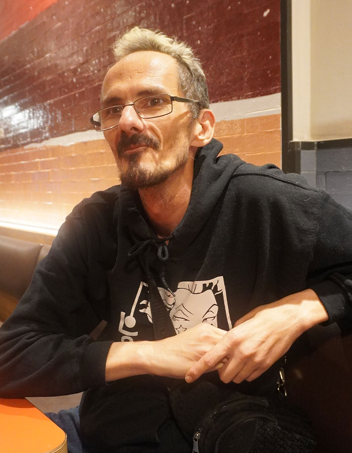 Man with glasses and light hair sitting indoors, representing streamer’s passing and family breaking silence after agony. Man with glasses and light hair sitting indoors, representing streamer’s passing and family breaking silence after agony.
