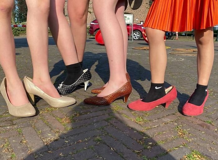 Close-up of women’s feet wearing stylish heels on a cobblestone street, capturing powerful street photos of everyday life.