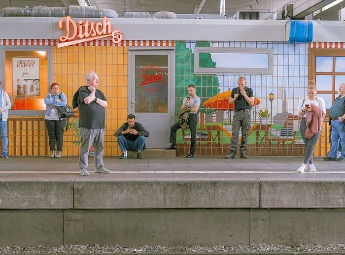 People waiting at a train station, captured in a powerful street photo showcasing the beauty of everyday life.