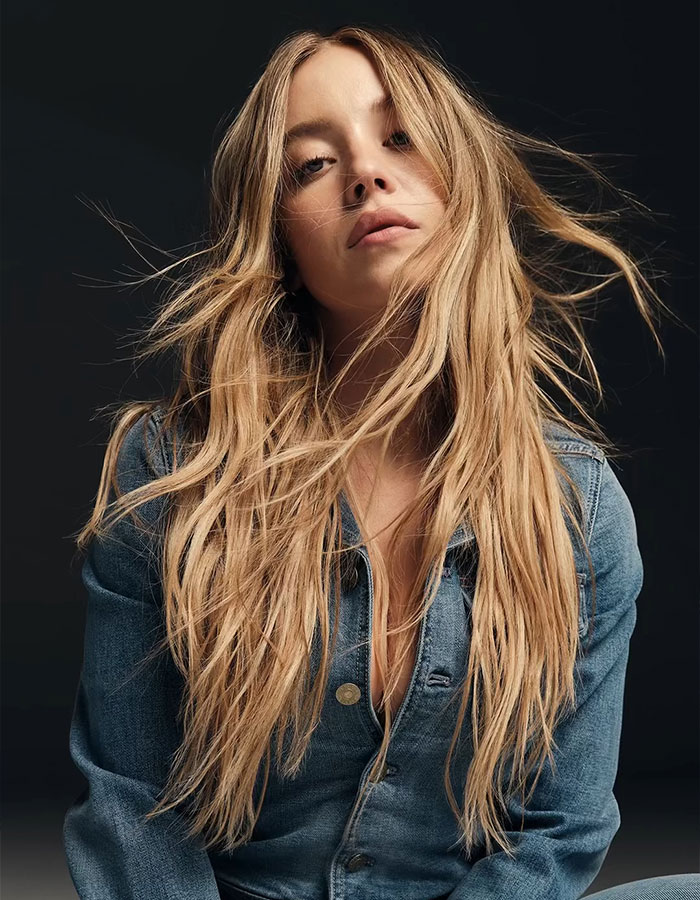 Sydney Sweeney posing with long hair in a denim jacket, reflecting on movie flop and American Eagle backlash news.