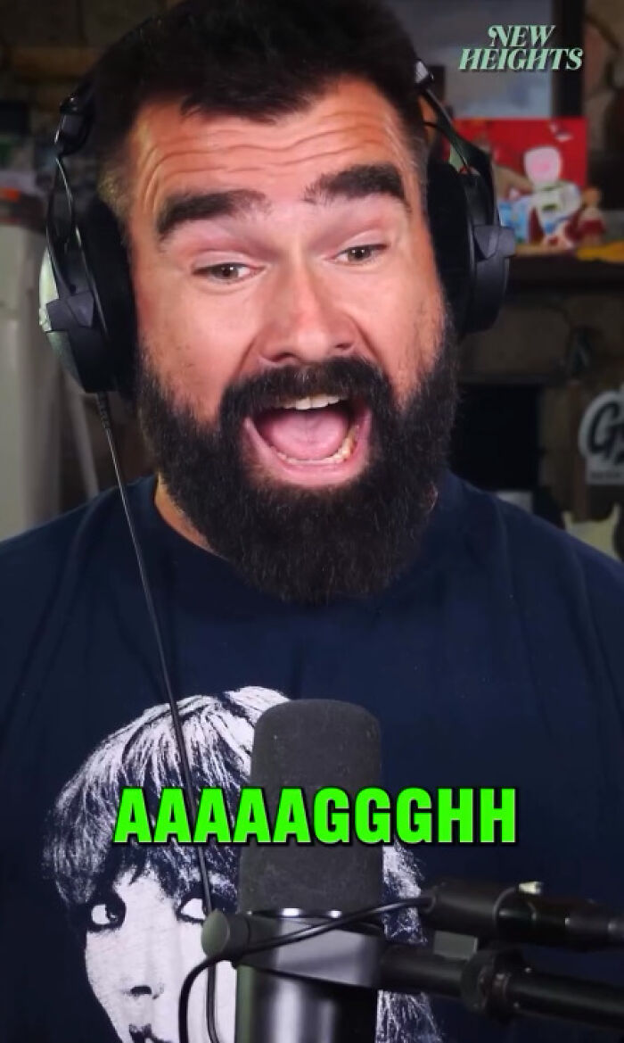 Man with a beard wearing headphones, reacting excitedly in a podcast studio about Taylor Swift mysterious countdown and album reveal.