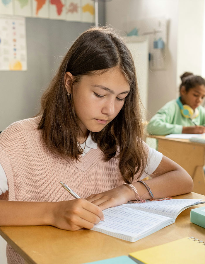 Student writing in a notebook during a classroom lesson inspired by teacher's private parts song for first grade kids viral video. Student writing in a notebook during a classroom lesson inspired by teacher's private parts song for first grade kids viral video.