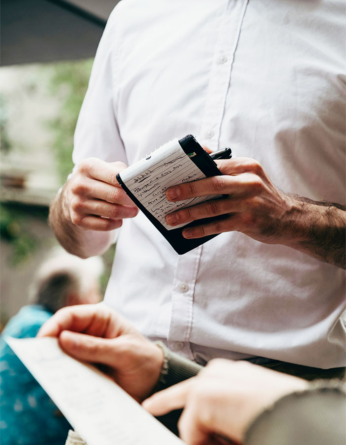 Restaurant server taking order from customer, illustrating a teen forced to prove gender in disturbing altercation.
