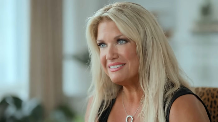 Woman with long blonde hair and black top speaking in an interview about New Netflix doc on Biggest Loser and PTSD effects.
