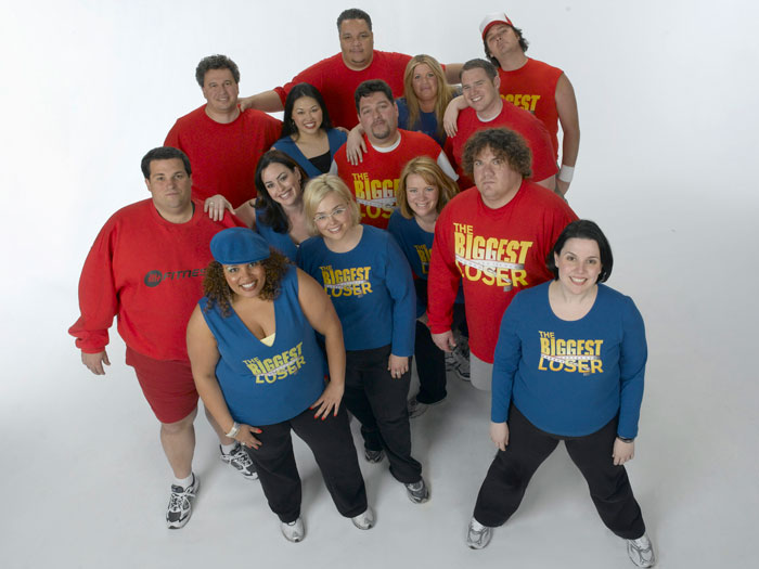Contestants from The Biggest Loser posing together in branded shirts, highlighting weight loss and emotional struggles documentary.