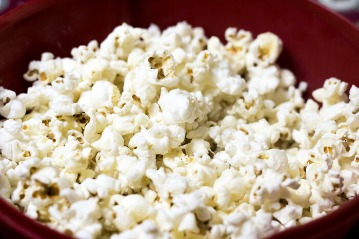 Close-up of popcorn in a red bowl illustrating a then vs now scenario with a focus on snack evolution and preferences.